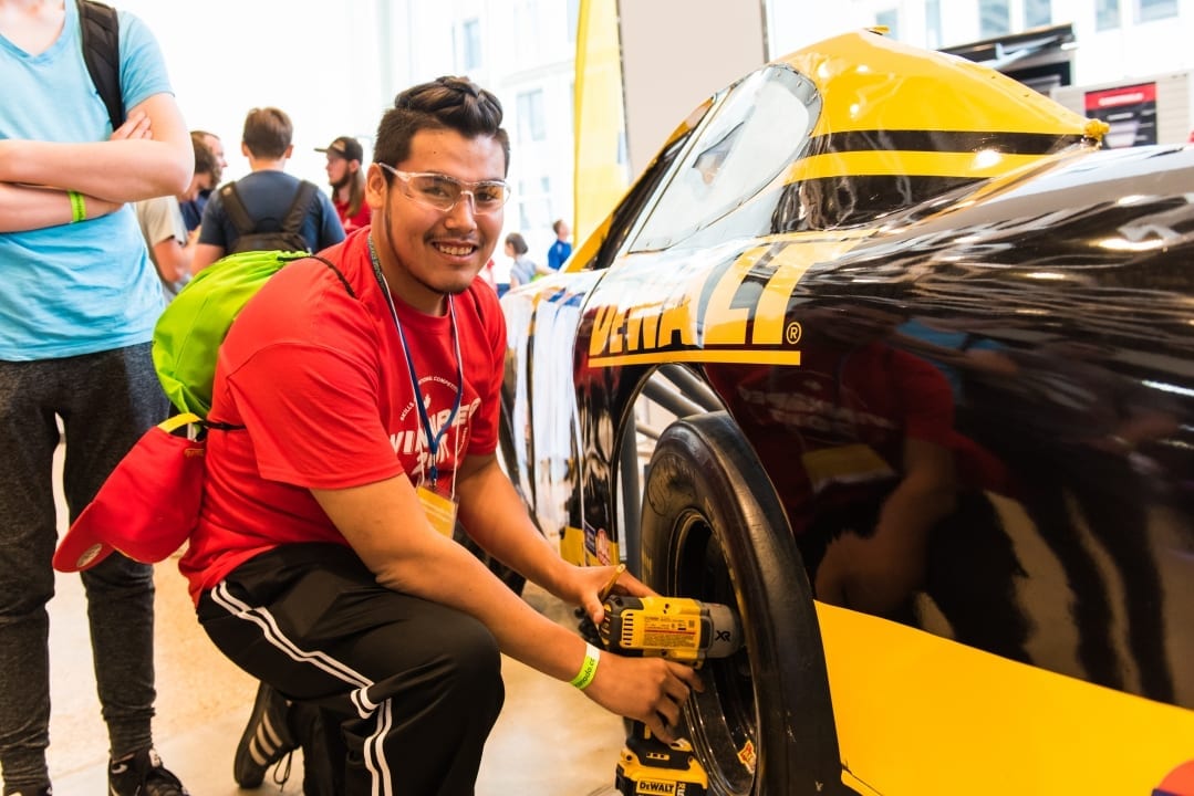 A man working on a car with Stanley Dewalt Logo